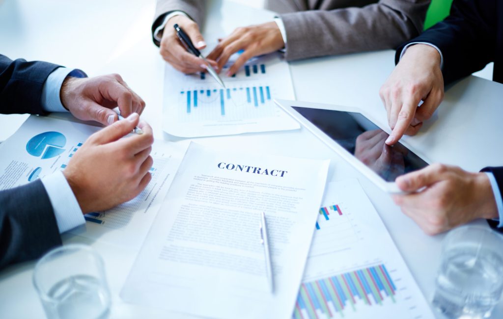 Image of business documents, touchpad, pen and glasses on workplace at meeting